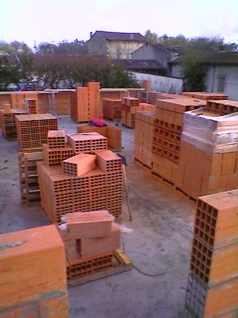 Maçon posant des blocs béton sur un mur